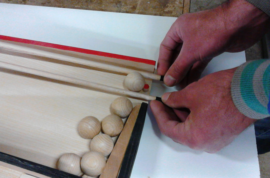 Moyen de saisir la boule : les baguettes de guidage passent dessous la boule et se resserrent afin de la faire monter dessus.